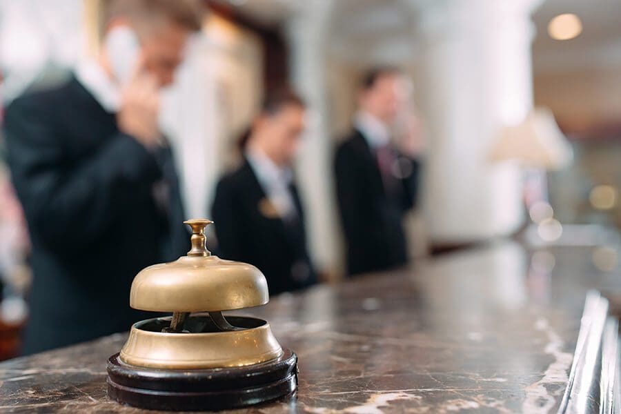 Hospitality Insurance - Front Desk Associate on the Phone with a Bell on the Desk of a Luxury Hotel