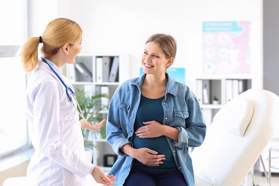 Pregnancy Medical Clinic Insurance - Young Pregnant Woman Visiting Her Doctor in a Clinic